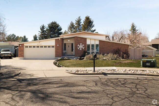 This Contemporary House, in Riverdale, UT, sits on a side walk lined street.