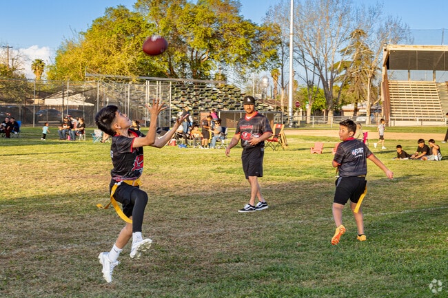A young Wasco flag football team warms up with their coach before the start of tonight's game.