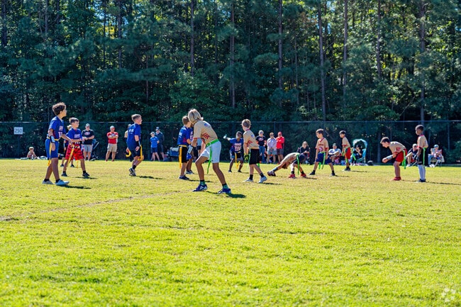Children play flag football on the grassy fields of Baileywick Park in Raleigh’s Stonehenge area.