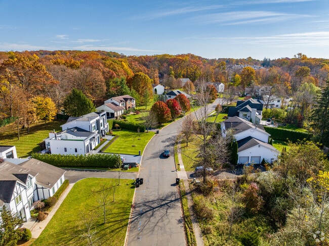Residential streets are beautifully lined with tall trees that display vibrant fall colors.