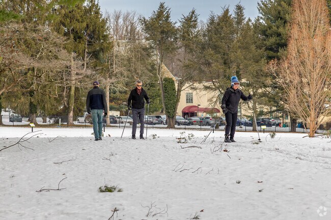 Ashbridge Park in Bryn Mawr transforms into a picturesque winter landscape, framed by mature trees and open green spaces.