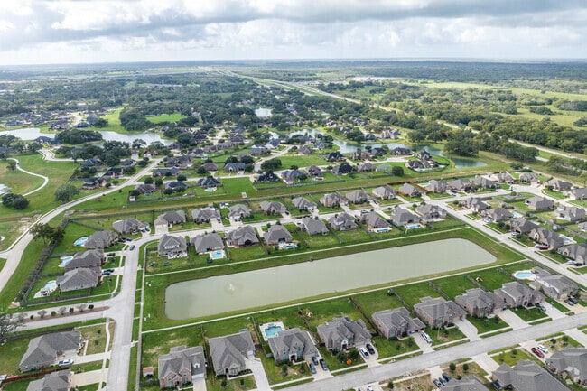 Neighborhood homes sit adjacent to a pond in Angleton, Texas.