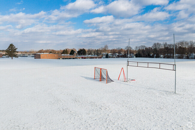 West Genesee Intermediate School has a very large sports field with a soccer net and goal post.