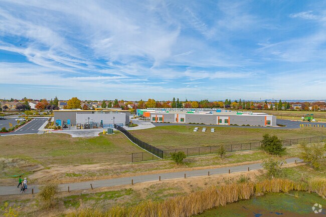 People walk along bike trail south side of Scott M. Leaman Elementary School.