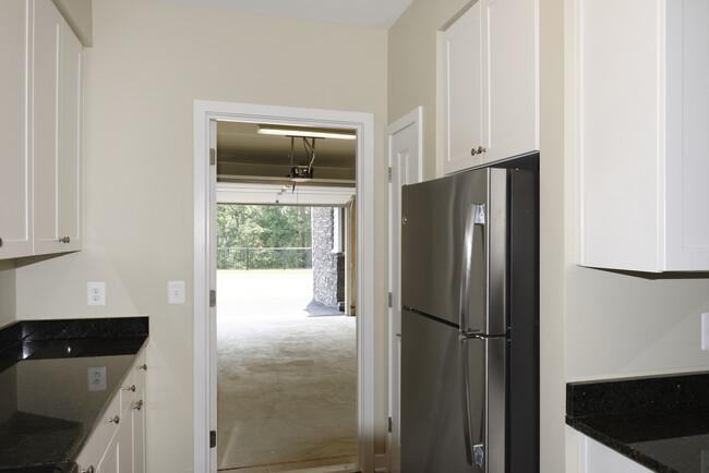 Open concept kitchen with white shaker cabinetry, granite countertops, kitchen island, stainless steel appliances and hard surface flooring