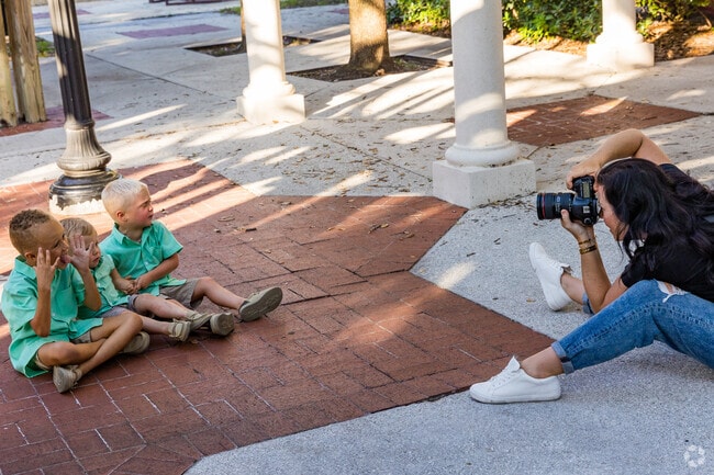 A family photographer captures cherished moments amidst the beauty of Village Walk.