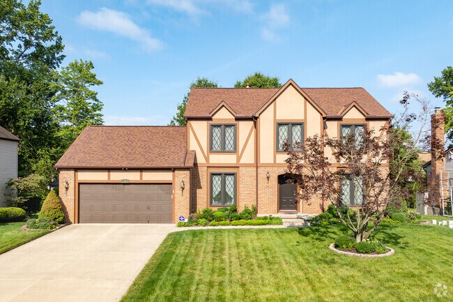 A Tudor style home in gahanna features a well-manicured front lawn.