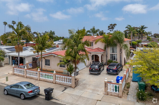 Palm trees stand tall over a modern red tile roofed home in Serra Mesa.