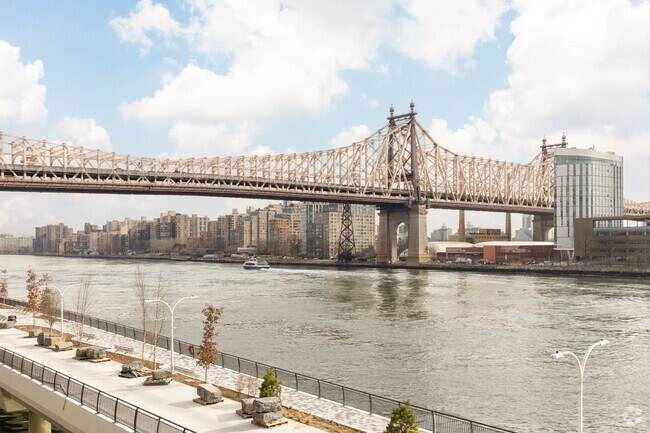 The Queensborough Bridge gracefully spans the East River, connecting Sutton Place's elegance.