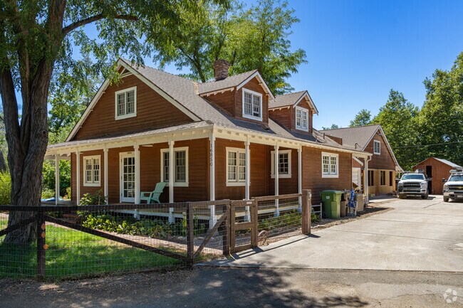 A mid 20th century home is shaded by the trees along this small road in Garden Farms.