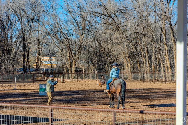 A man a woman take a photo opportunity on a horse in Corrales.