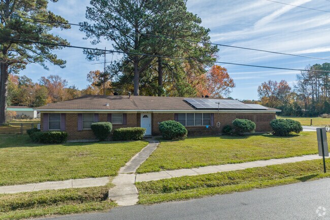 Well trimmed hedges grace the exterior of this all-brick mid-century rancher in Mansfield, LA.