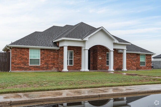 A red brick style home with white columns located in the south side of Palmview, Texas.