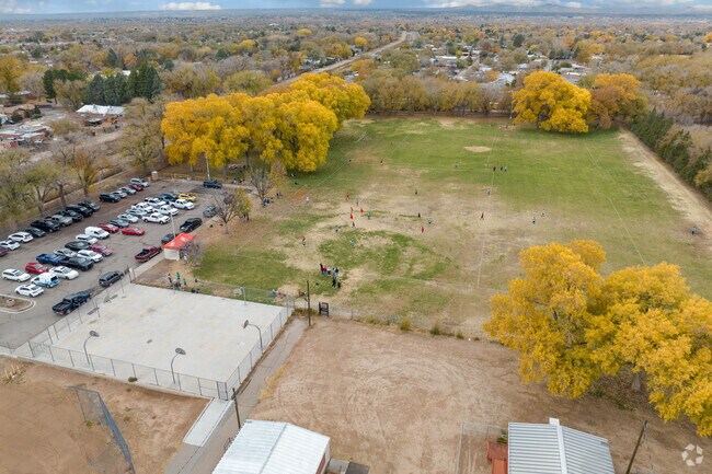 A soccer game is taking place in the grass fields behind Garfield Middle School.