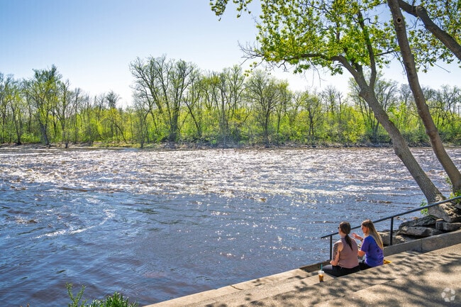 Seating areas and walking path line the riverfront area in the city of Little Falls.