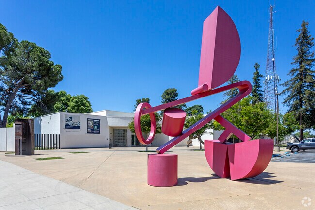 A large red sculpture stands outside the Fresno Art Museum located in the McLane area.