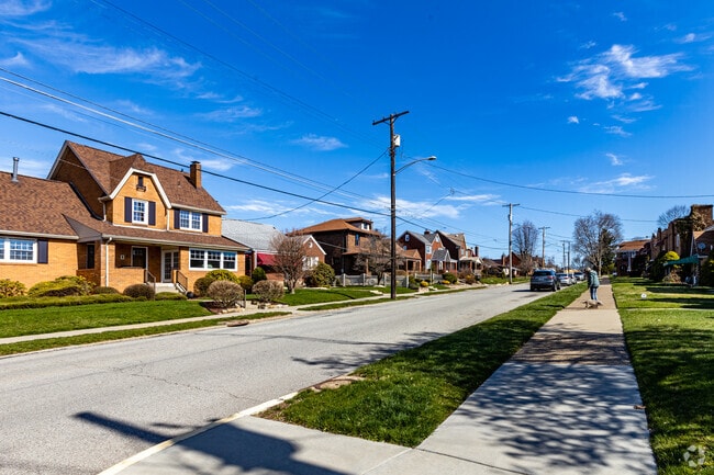 Rows of beautiful houses line the streets of Munhall and large yards are visible throughout.