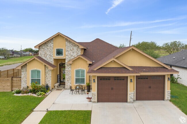 This house has a beautiful facade with stone accents and a double-car garage.