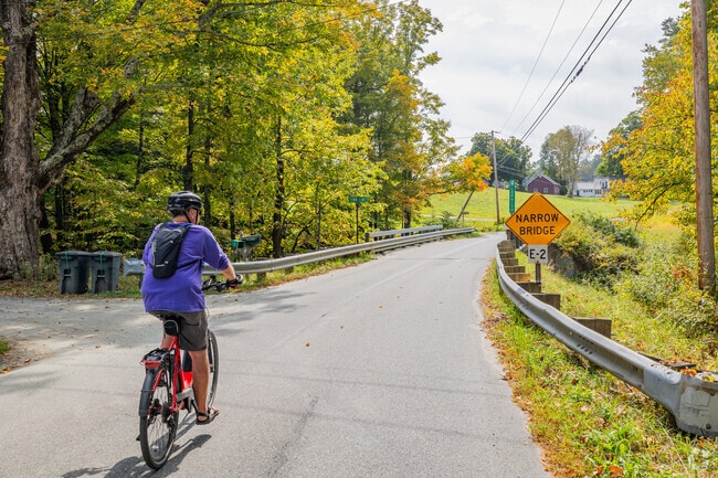 A cyclist rides down a country road in the Cornish Colony Neighborhood.