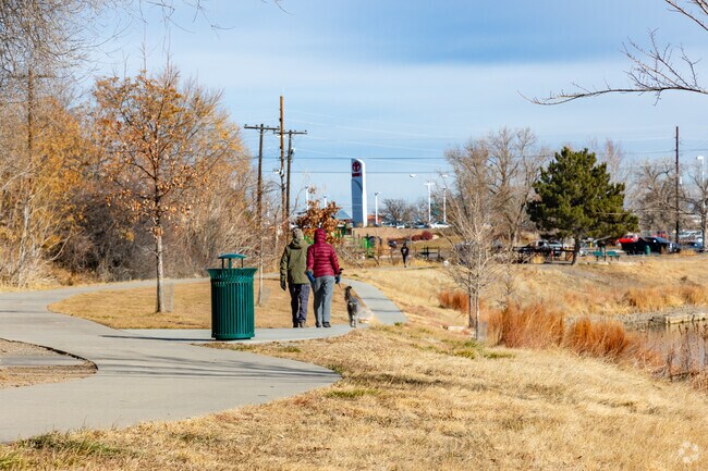 Twin Lakes Park in Denver has a scenic walking trail surrounding a pond.