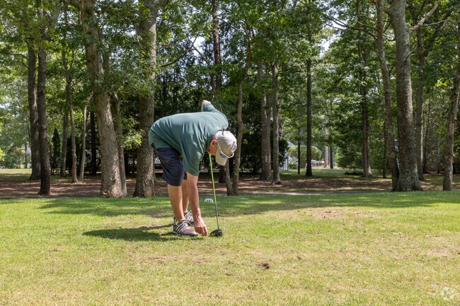 A resident prepares his tee at the Paul Harney Golf Course in Hatchville.