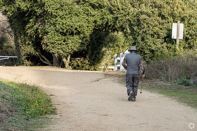 A hiker hiking towards the large dirt parking lot at the Powder Canyon trailhead in La Habra.
