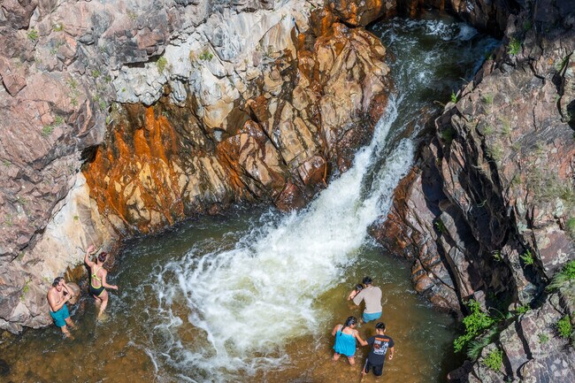 A family enjoys playing in the cool water at the base of Nambe Falls.