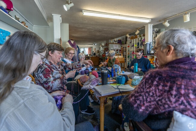 A group of people knit together at Knitty Gritty Yarn Shop near Greenfield.