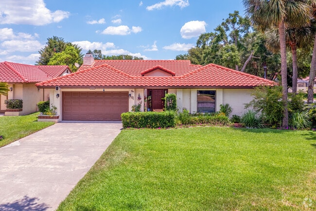 A red tile roof and meticulous landscaping display ownership pride in this Dr. Phillips home.