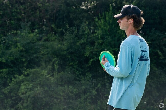 A WMU student studies the disc golf course at Knollwood Park for his next move.