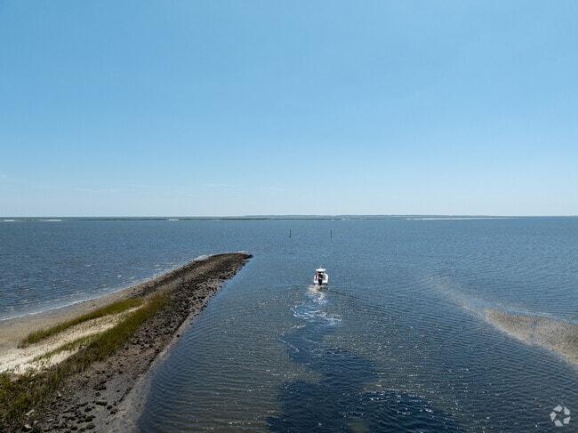 A motorboat glides from a tidal channel into Apalachicola Bay near Lanark Village.