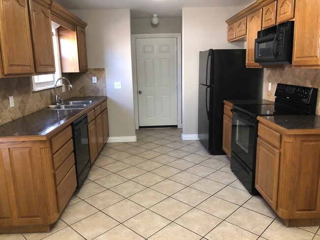 Kitchen view toward garage entry and utility area