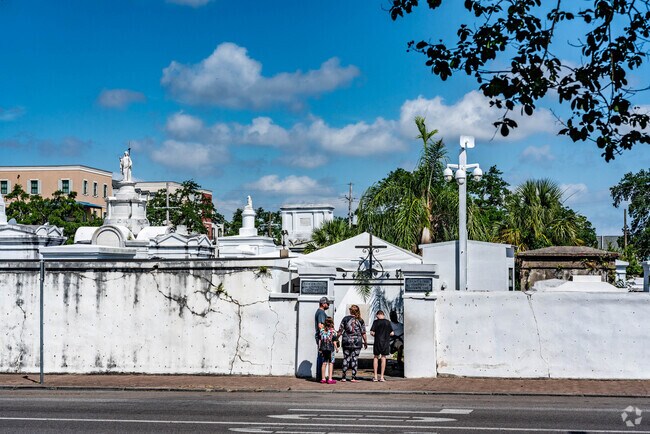 People walking into the front entrance of Saint Louis Cemetery No1 in the Iberville neighborhood.