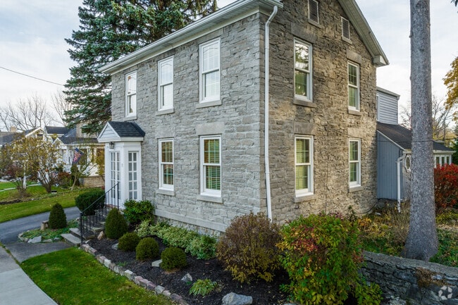 A unique home with a stone facade is viewable from the sidewalk in Amherst, NY.