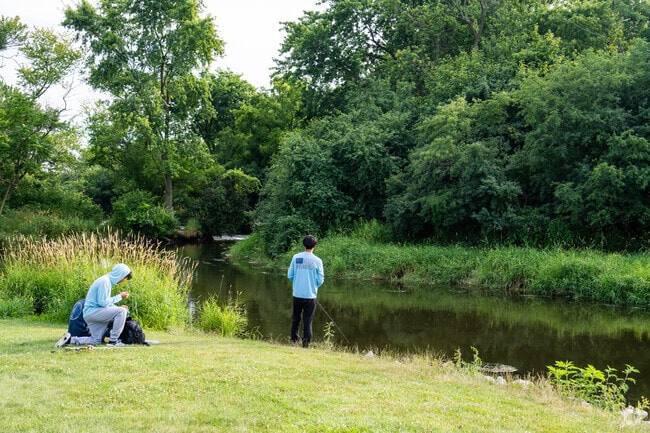 Young residents fish along the banks of the river in Isle a la Cache Preserve.
