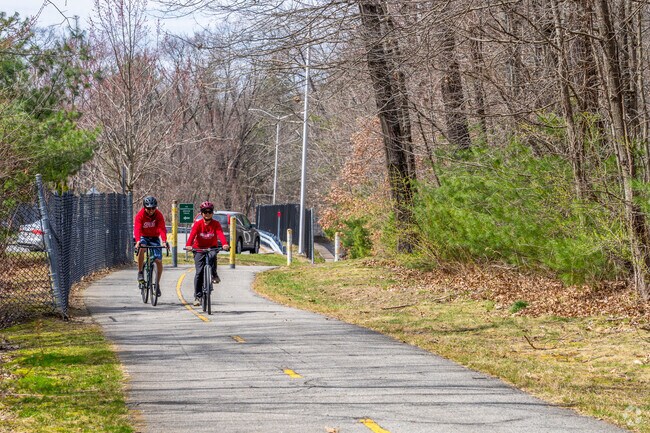 A couple of folks ride their bicycles along the Assabet River Rail Trail in Marlborough.
