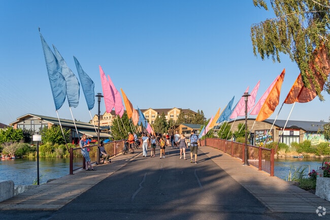 People cross from one side of Southern Crossing to the other using a bridge over the Deschutes.