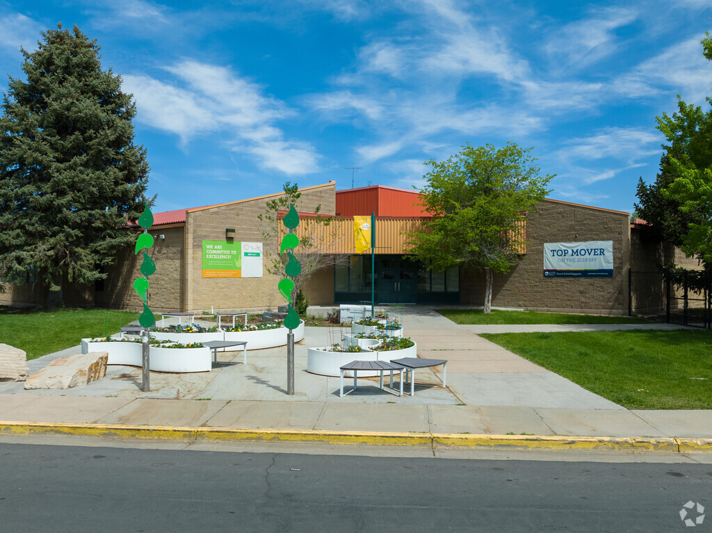 The artistic entrance to Amesse Elementary School features plants and seating areas.