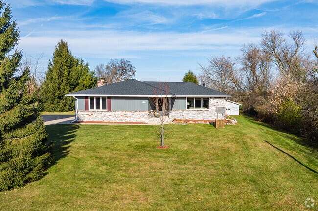 Ranch-style homes are common in Lac La Belle, and many are surrounded by trees.