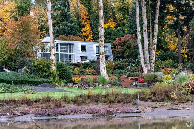 A modern home is tucked behind trees along the Willamette River in the Birdshill neighborhood.