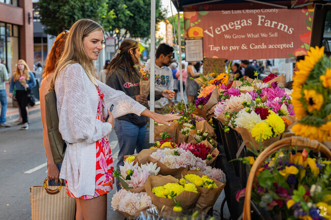 A college student carefully picks out the best flowers at the Downtown SLO Farmers' Market.