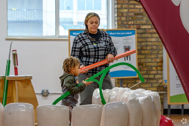 A mother and her child learn about flossing at Impression 5 in The Stadium District.