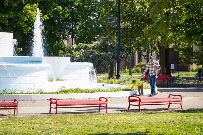 Parents and their children enjoy the peaceful walk by the water fountain in Central Park.
