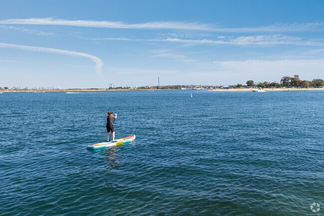 A paddle-boarder enjoys the calm waters before sunset.