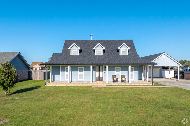 A Cape Cod home with a spacious front porch in Bourg perfect for enjoying a hot Louisiana day.