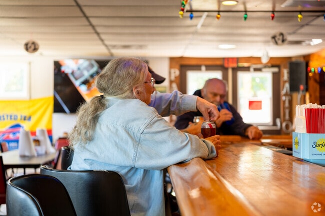 People enjoying company and drinks at the bar in Beachcombers