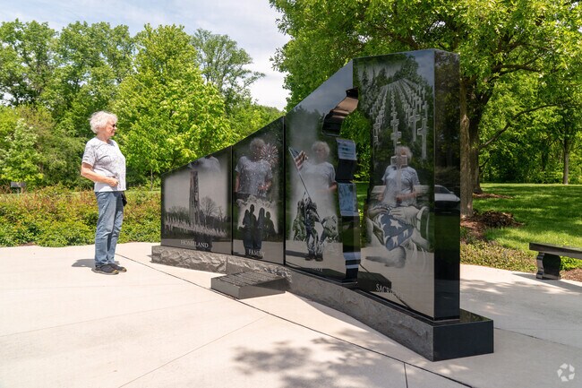 Proud resident admires the Armed Forces Memorial located in Hobson Village's Veterans Park.