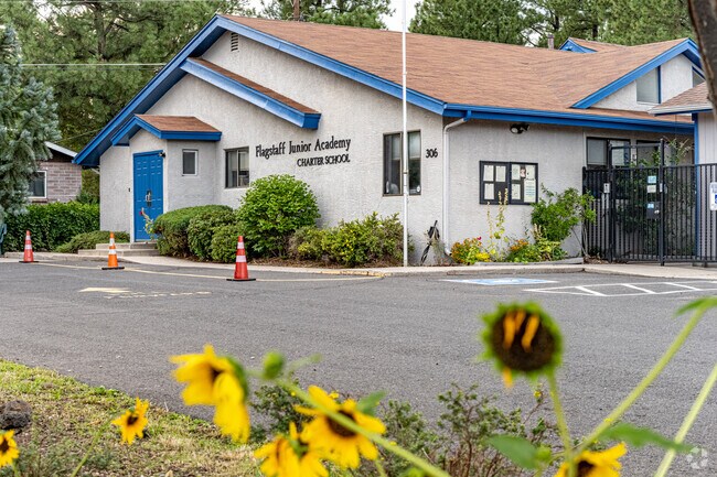 Flagstaff Junior Academy is surrounded by large natural trees and flowers.