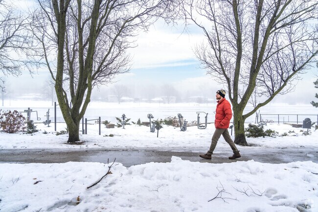 A man walks on the path encircling Volkening Lake.