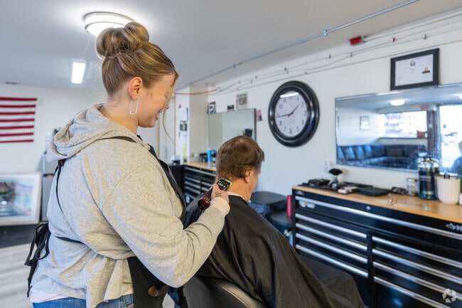 A barber at Mane Street Barbershop, near Deering, cuts a client's hair.